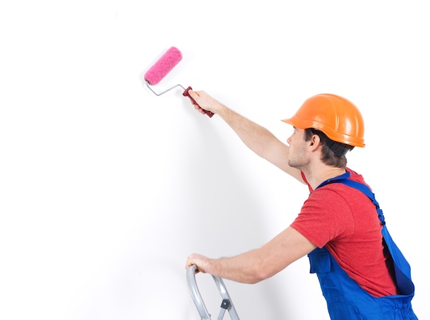 Free photo craftsman painter stands on the stairs with roller, portrait on white