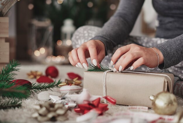 Craftswoman decorating a  wrapped gift