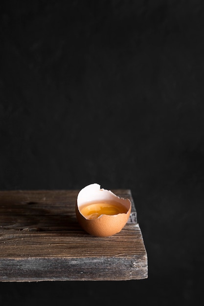 Craked egg on wooden board