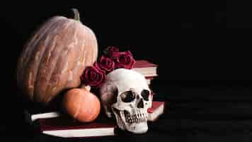 Free photo cranium with roses and pumpkins