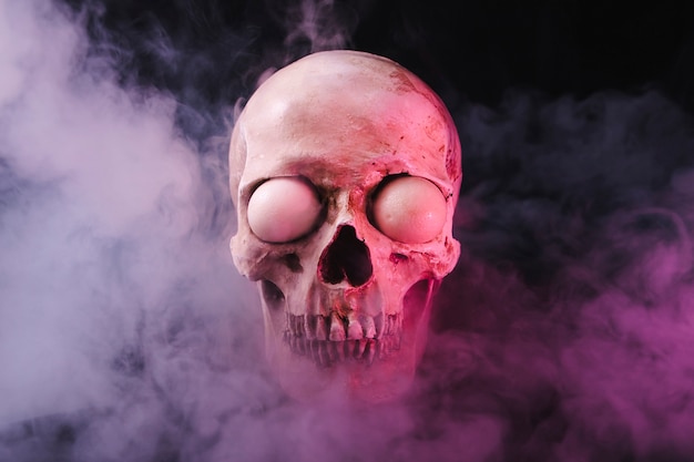 Free photo cranium with spooky eyeballs in smoke