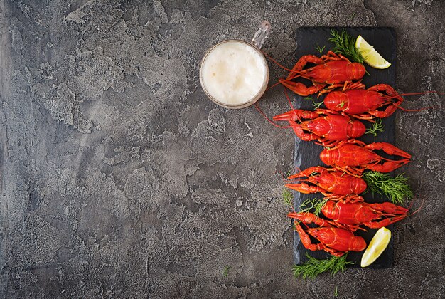 Crayfish. Red boiled crawfishes on table in rustic style, closeup. Lobster closeup. Border design. Top view. Flat lay.