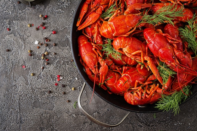 Crayfish. Red boiled crawfishes on table in rustic style, closeup. Lobster closeup. Border design. Top view. Flat lay.