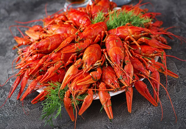 Crayfish. Red boiled crawfishes on table in rustic style, closeup. Lobster closeup. Border design