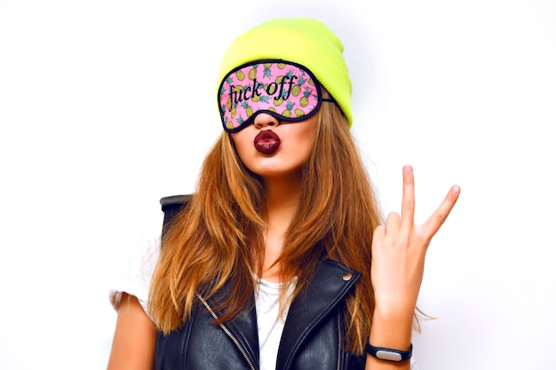 Foto gratuita donna pazza e sfacciata hipster che indossa un cappello al neon e una divertente maschera per gli occhi. stile urban swag, invio di bacio, rossetto scuro alla moda, yo scienza, flash.