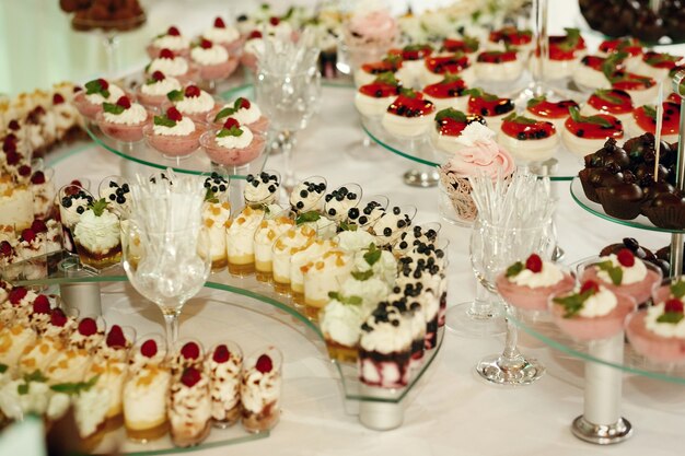 Cream cakes with berries served on curved glass dishes 