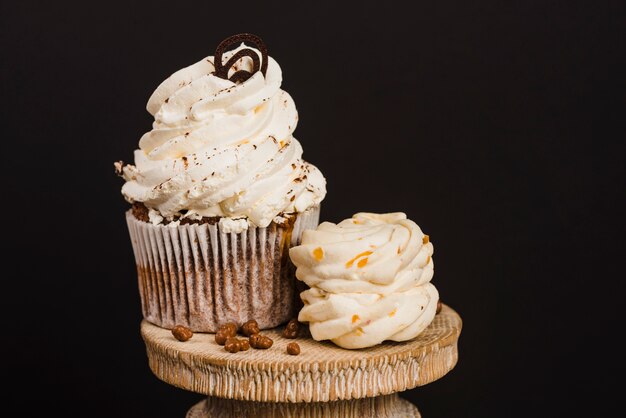 木製のケーキスタンドのクリームカップケーキ