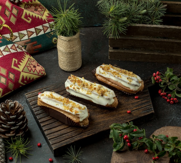 cream eclairs on wooden board