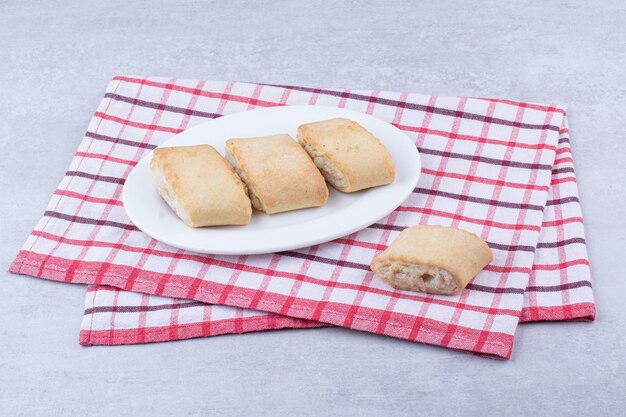 Cream filled biscuits on white plate.