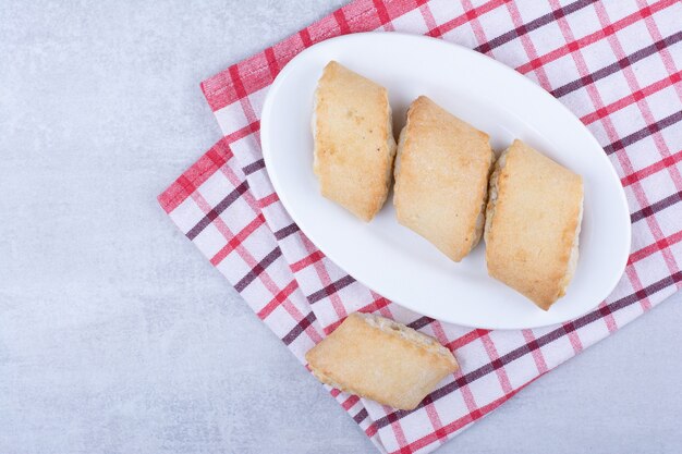Cream filled biscuits on white plate.