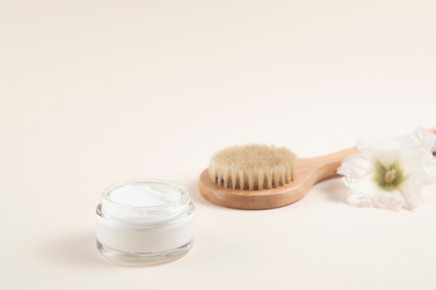 Cream and hair brush layout with plain background