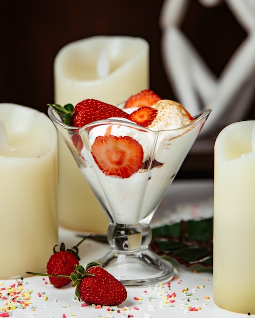 Cream mousse with strawberries around candles.