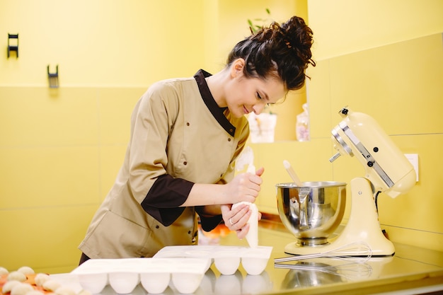 Free photo cream in a pastry bag. lady with a baking tool.