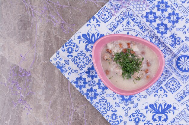 Cream soup with beans in broth served with minced herbs