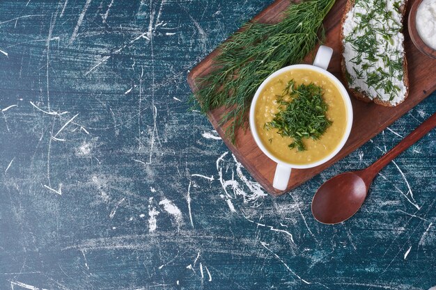 Free photo cream soup with herbs and bread toast.