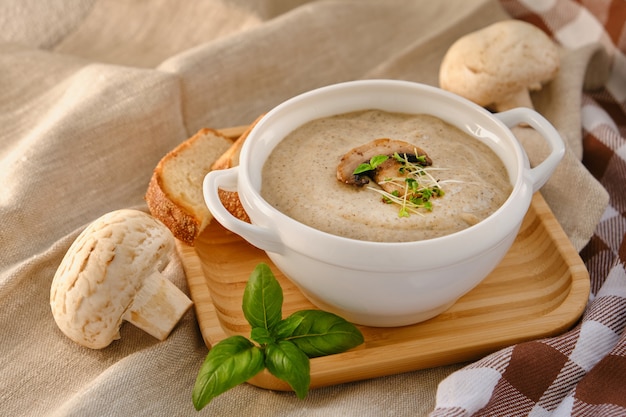 Cream soup with mushrooms champignon in white bowl Premium Photo