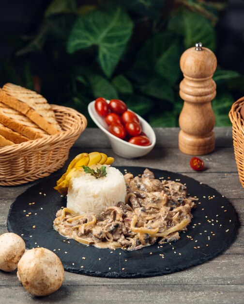 creamy mushroom served with rice in a round stone plate