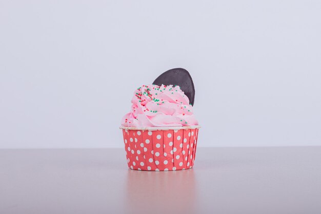 Creamy pink cupcake on white