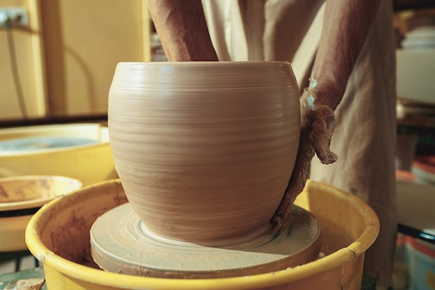 Создание кувшина или вазы из белой глины крупным планом. Мастер черепок.