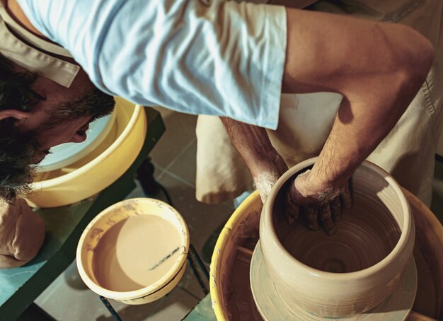 Creating a jar or vase of white clay close-up.