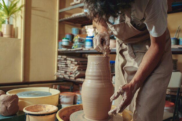 Creating a jar or vase of white clay close-up.