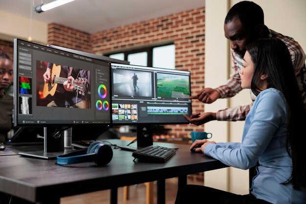 Creative agency video graphic editor expert enhancing footage using visual timeline and advanced software. Asian woman sitting in office workspace working on film project.