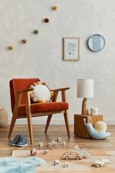 Креативная композиция интерьера уютной скандинавской детской комнаты с макетом рамки плаката, красным креслом, плюшевыми игрушками и подвесными украшениями. креативная стена. шаблон.