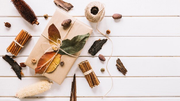 Creative composition with gift on white wooden background