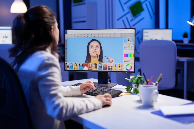 Creative creator doing portrait retouch using color grade late at night in professional editing office