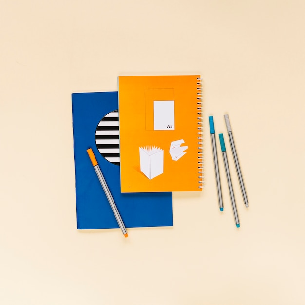 Free photo creative decorated notebooks with colorful felt tip pens on colored notebook