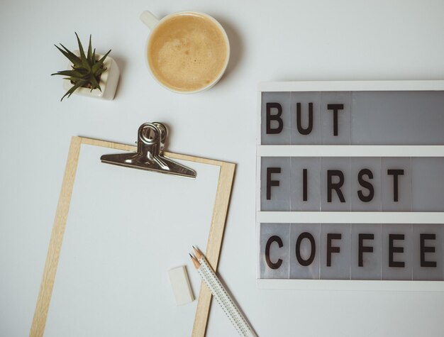 Creative desk But first coffee workspace with clipboard pen mug on white background Flat lay top view