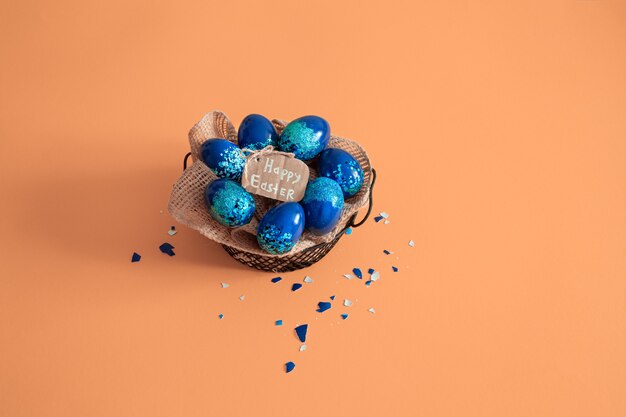 Творческий пасхальный макет из разноцветных яиц и цветов на синем фоне. Концепция плоской планировки венок круга. Концепция пасхальных праздников.