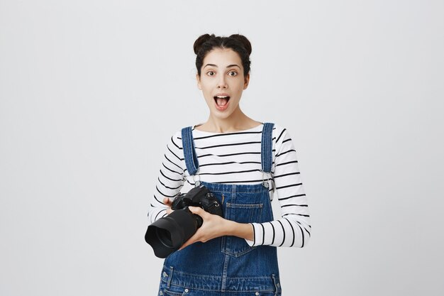 Creative excited girl photographer holding camera, taking pictures