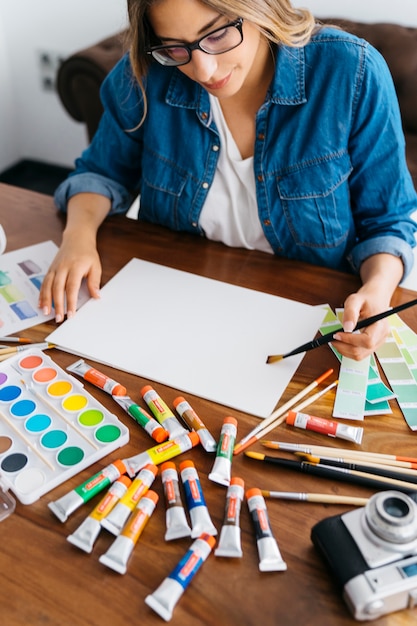 Free photo creative female artist holding paintbrush