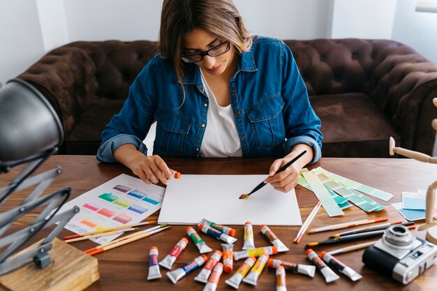 Creative female artist painting at desk