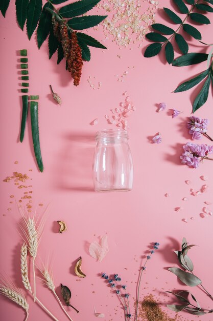 Creative flat lay top view of empty bottle on pastel millennial pink paper wall copy space.