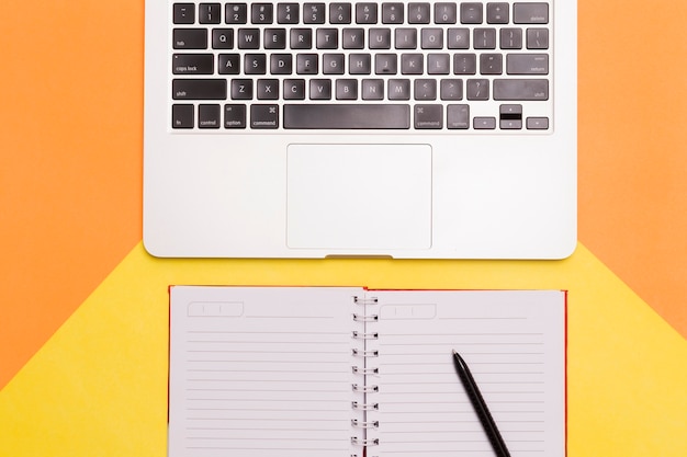 Creative flat lay of workplace desk with orange and yellow background 