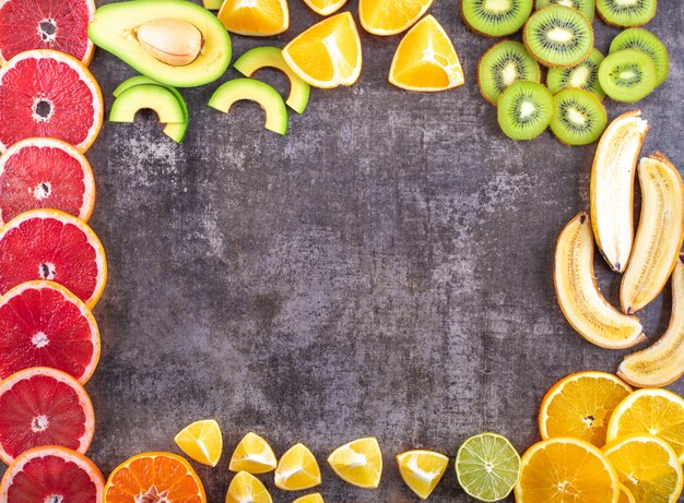 Креативная рамка со свежими вкусными цитрусовыми фруктами сверху грейпфрута авокадо киви банан апельсин лимон с копией пространства