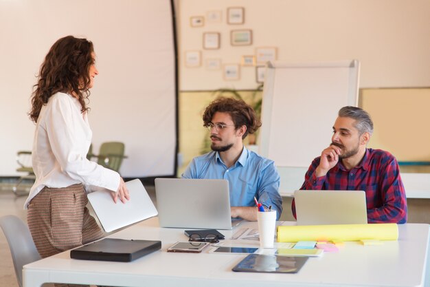 Creative group with laptops gathering in meeting room