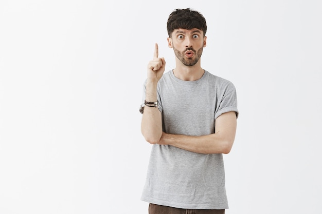 Creative handsome guy posing against the white wall