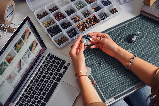 Foto gratuita la creatrice di gioielli creativa sceglie la conchiglia giusta per il suo nuovo progetto.