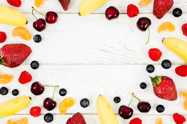 Creative layout of fruits on wooden background