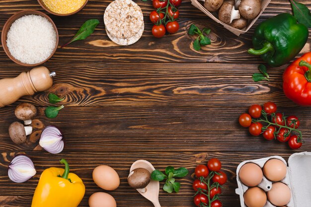 Creative layout made of fresh vegetables and rice grains on wooden desk