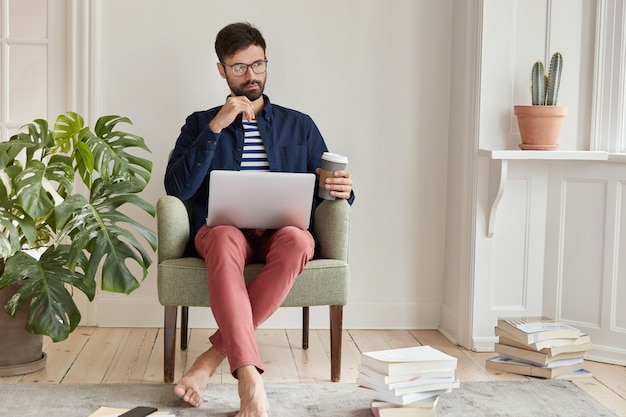 Creative male freelancer posing in cozy apartment