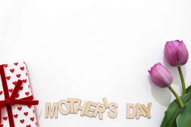 선물 상자와 두 개의 장미와 창조적 인 어머니의 날 레터링