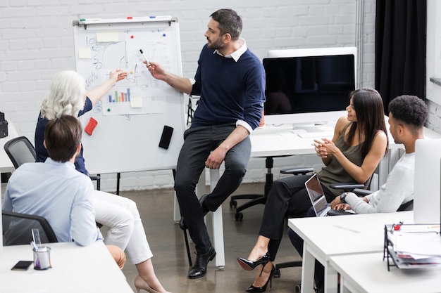 Creative people sitting at table in boardroom