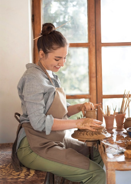 Free photo creative person working in a pottery workshop