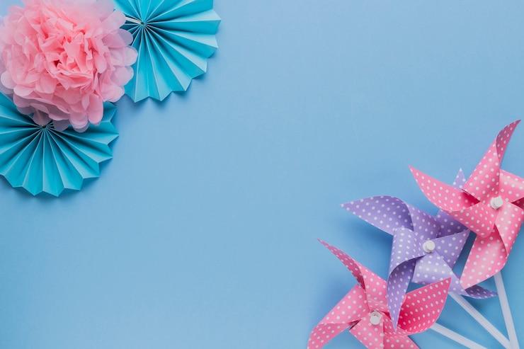 Free Photo creative pinwheel and beautiful paper flower at the corner of plain background