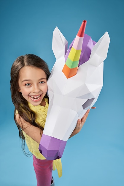 Creative portrait of child with white 3d unicorn head.