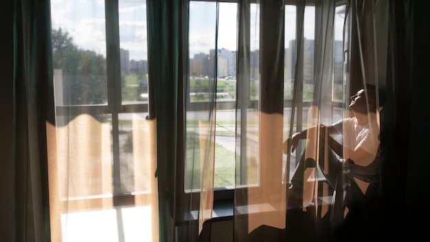 Free photo creative portrait of man with curtains and shadows from window